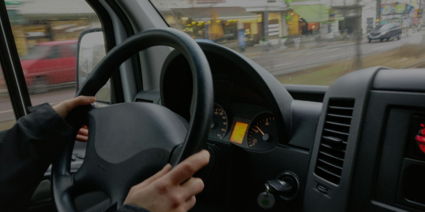 Hands on the steering wheel of a car on the road